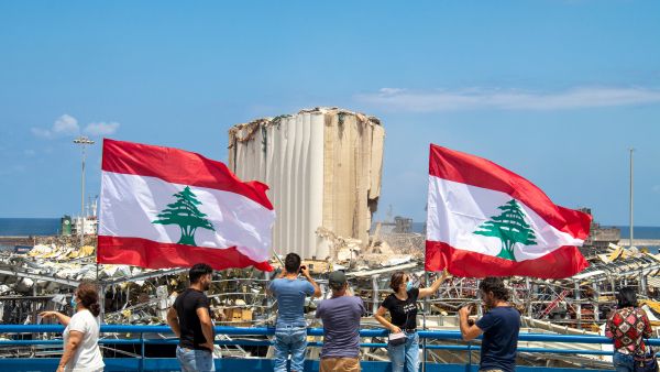 Lebanese flags flying in front of the destruction at the port in Beirut