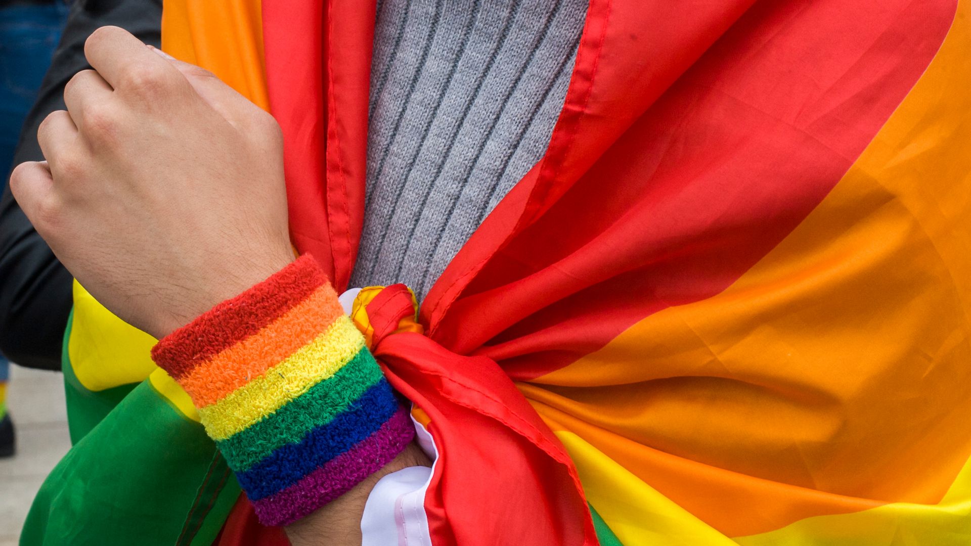 Protestor at a pro-LGBTI rally in Warsaw, Poland wrapped in a rainbow flag