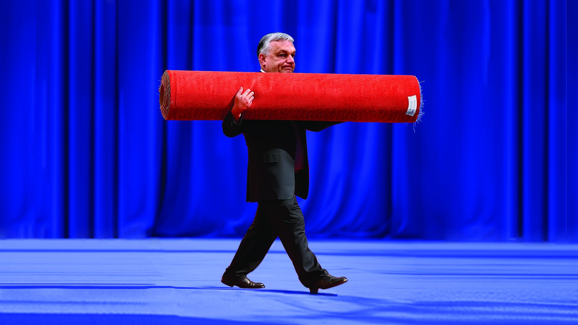 Image of Orban holding a rolled up red carpet