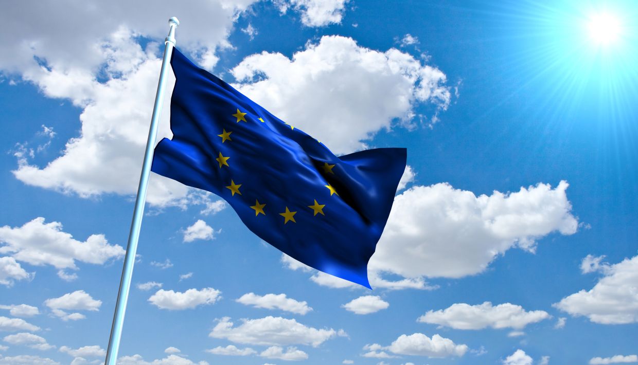 EU flag in sky sunny clouds