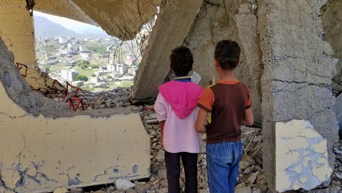 Children in Yemen looking at the ruins of their school