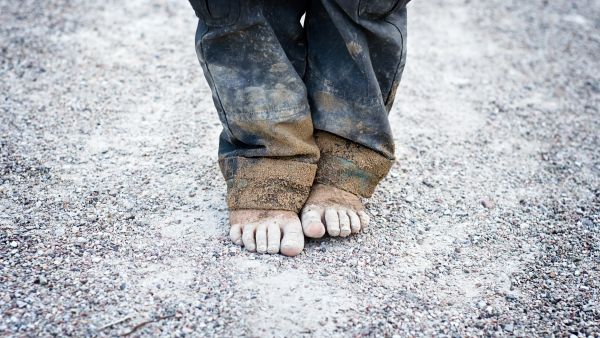 childs dirty feet on gravel
