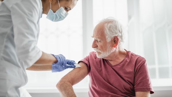 Elderly man receiving a vaccination