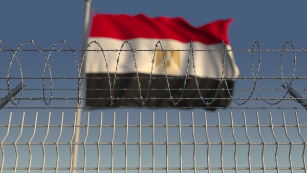 Egyptian flag flying behind a barbed wire fence