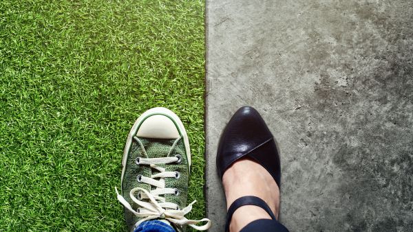 A pair of feet ready for work and leisure, one in smart shoes and one in trainers