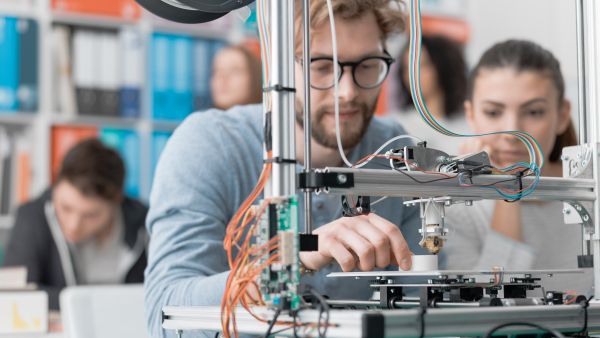 Engineering students using a 3D printer