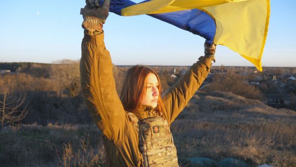Image of Ukrainian woman soldier holding flag