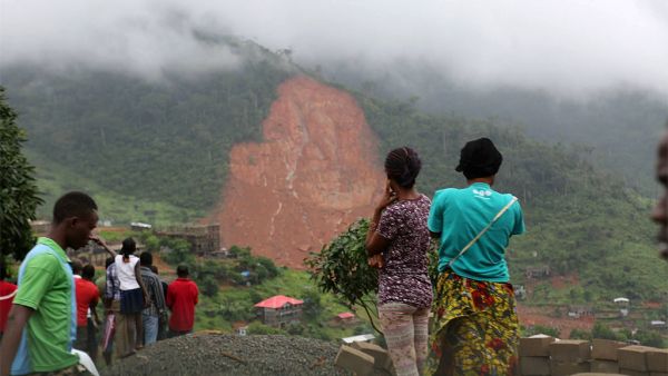Civilians look on at landscape devastated by floods and landslides in Sierra Leone