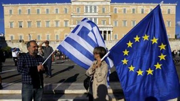 It is now time to address Greece’s debt relief, says Udo Bullmann, Eurozone and the International Monetary Fund (IMF), EU macro-economic assistance programme, People holding Greek and EU flag