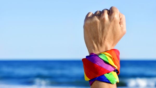 LGBTI hand wearing multi coloured scarf in air