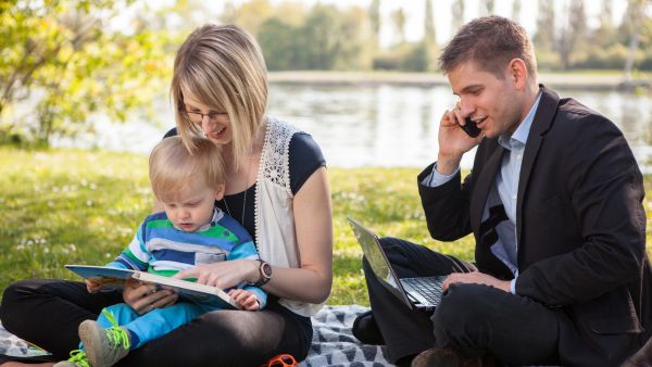 parents and baby in park - man working